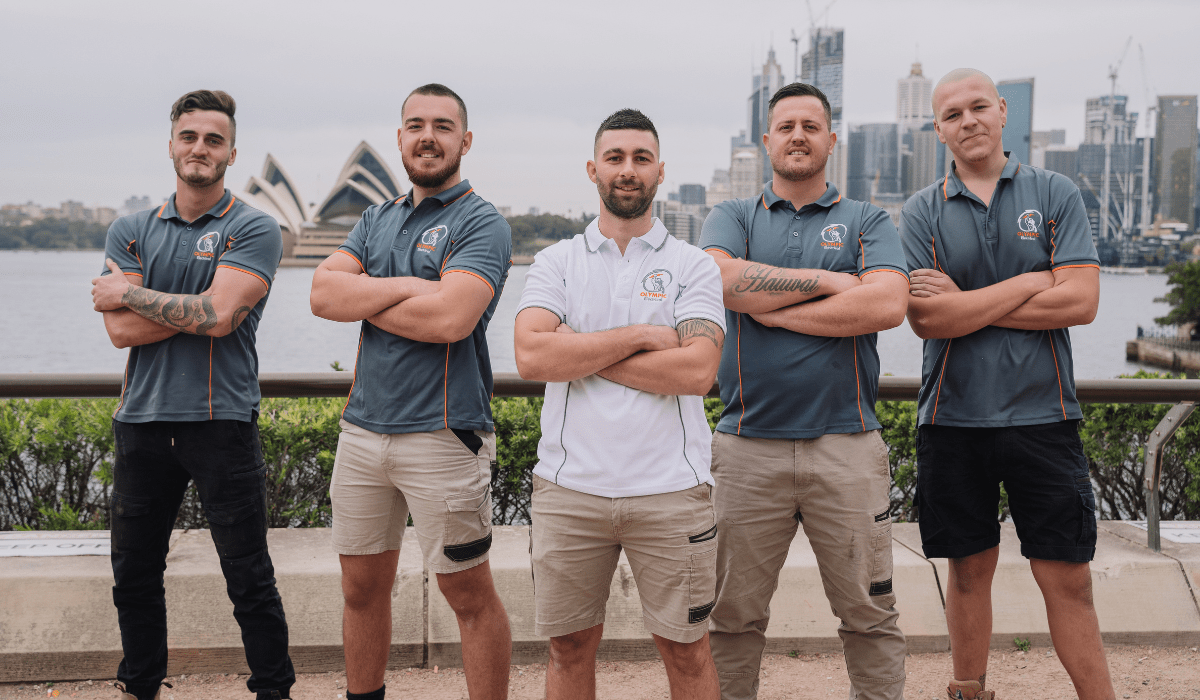 Team of Marrickville electricians standing with arms crossed in front of Sydney Opera House.